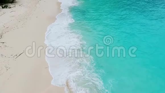 热带海滩上的海浪白沙和晶莹湛蓝的大海空中景观视频的预览图