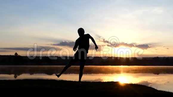 太阳落山时欢乐的人在湖岸上跳迪斯科视频的预览图