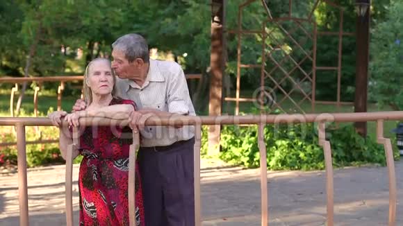 关怀的祖父在凉亭公园亲吻他的妻子视频的预览图