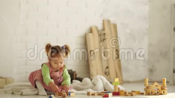 一个漂亮的婴儿在地板上玩木方块教育玩具学前教育幼儿园视频的预览图