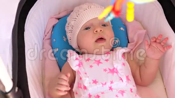活泼的女婴躺在婴儿车室外视频的预览图