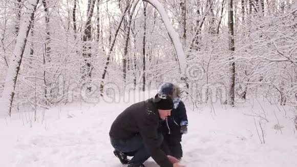 爸爸和他的小儿子向照相机扔雪视频的预览图