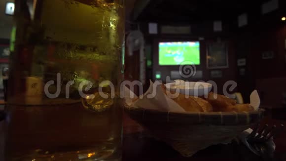 带足球比赛电视背景的体育酒吧提供啤酒和小吃视频的预览图