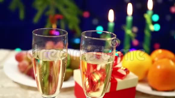 在有礼物的桌子上有两个带香槟的酒杯放在她祖国的新年背景上视频的预览图