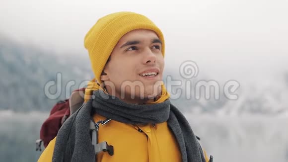 旅行者站在美丽的湖泊附近白雪覆盖的山脉中希克尔看着美丽的大自然视频的预览图