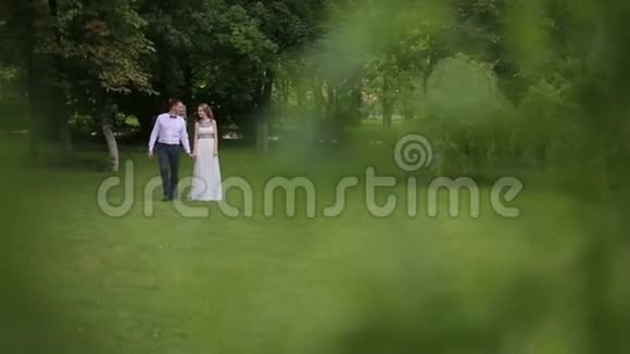 男人和女人穿着优雅的衣服在公园里散步视频的预览图