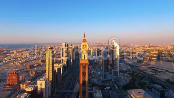 标志性的谢赫扎耶德公路摩天大楼和地标建筑的鸟瞰图日落时的迪拜城市道路和塔吉沃拉酒店的景观视频的预览图