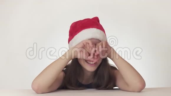 一位戴着圣诞老人帽子的美丽不幸少女在白色背景的股票录像中情绪激动地哭着视频的预览图