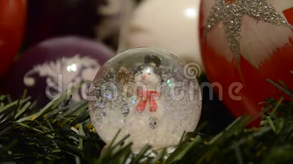 圣诞装饰品闪亮的神奇水晶球树枝上有雪人和圣诞球带有圣诞节背景的雪穹视频的预览图