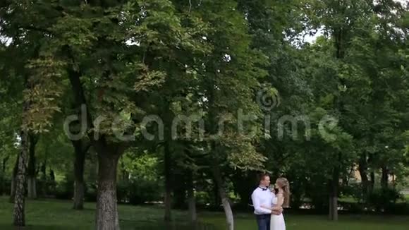 一对夫妇站在大树附近的怀抱里视频的预览图