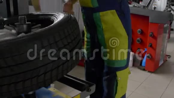 4K型轮胎钳工将轮胎从一个特殊工具上的车轮上拆卸下来视频的预览图