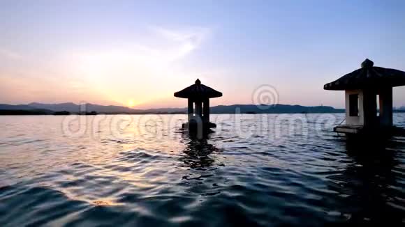 中国杭州西湖美丽的日落景观橙色黄昏的天空和宁静的水与传统的和平视频的预览图