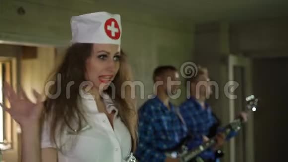年轻的女护士唱歌尖叫呼喊与疯狂的病人在精神病院疯狂吉他手表演视频的预览图