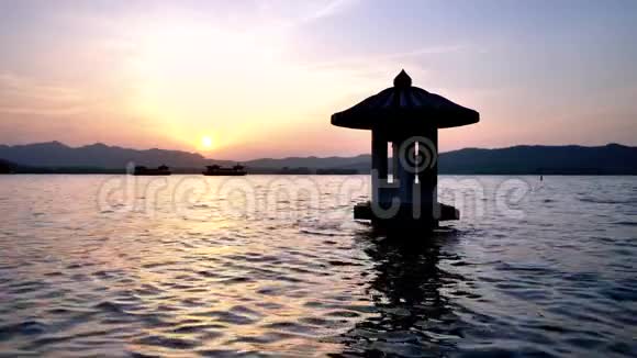 中国杭州西湖美丽的日落景观橙色黄昏的天空和宁静的水与传统的和平视频的预览图