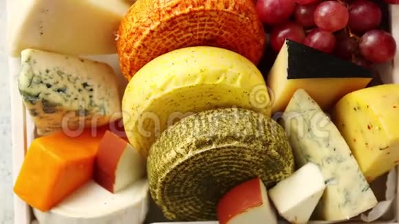 新鲜美味的不同种类的奶酪放在装有葡萄的木箱里视频的预览图