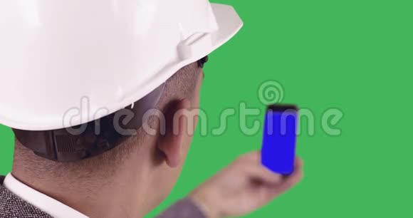 一个建筑工人拿着一部蓝色屏幕的手机视频的预览图