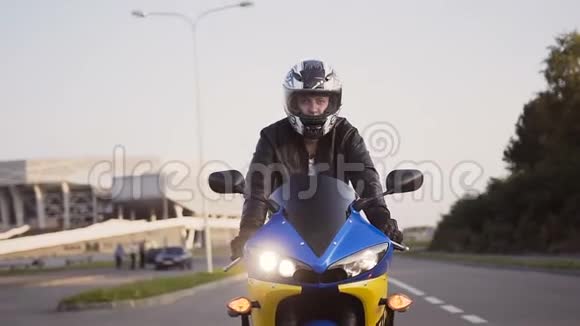 一个骑摩托车的人骑着一辆黄色蓝色摩托车头戴头盔头戴皮夹克视频的预览图