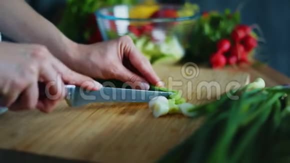 女人用手切葱做沙拉把新鲜蔬菜收起来视频的预览图