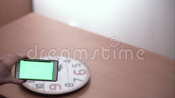 智能手机扫描时钟用绿色屏幕将手向右向左移动视频的预览图
