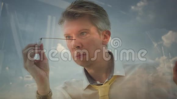 一个商人在玻璃上画房子的图像视频的预览图