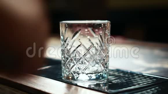 酒吧里的酒吧里酒吧老板把冰块倒进桌子上的玻璃里视频的预览图