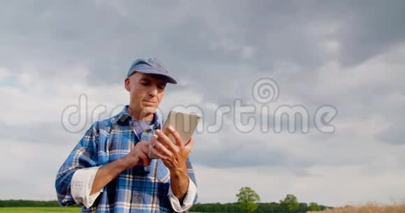 农民在农场使用数字平板电脑对抗蓝天和云彩视频的预览图