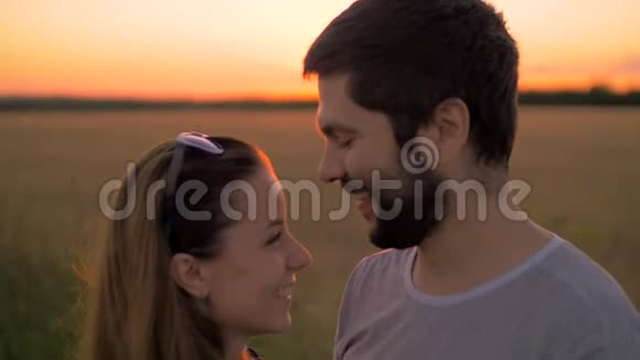 日落时分在麦田里接吻的年轻夫妇视频的预览图
