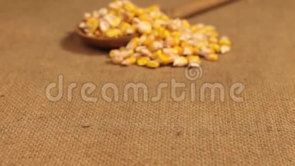 接近一个装满玉米粒的木勺躺在麻布上视频的预览图