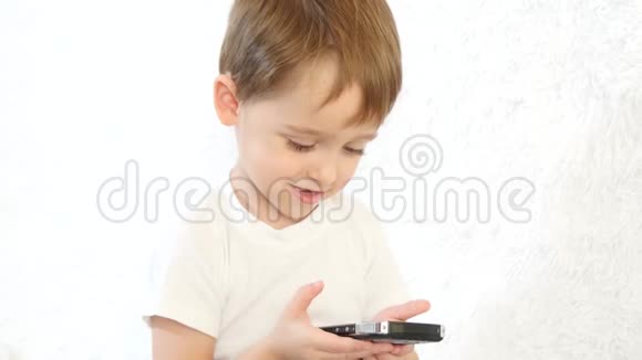 快乐的孩子在白色背景下玩智能手机孩子在笑特写镜头视频的预览图