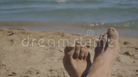 白种人的近足躺在海边的沙滩上视频的预览图
