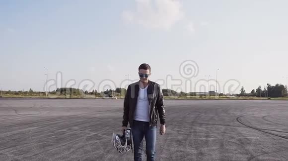骑自行车的人穿着皮夹克和牛仔裤坐在摩托车上戴着太阳镜视频的预览图