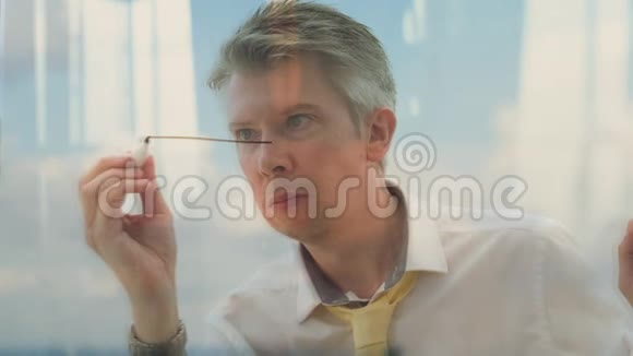 一个商人在玻璃上画房子的图像视频的预览图
