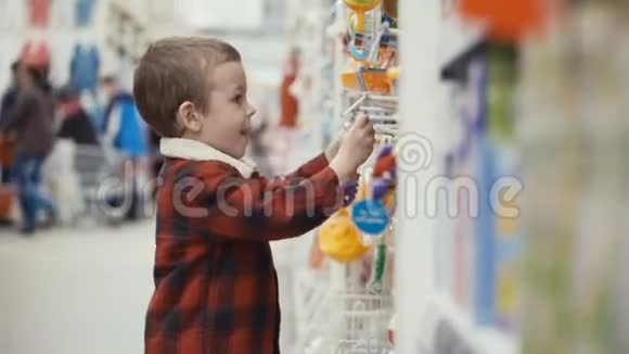 小男孩站在商店里挑选玩具视频的预览图