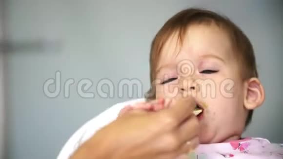 妈妈用一勺蔬菜喂小孩吃午饭视频的预览图