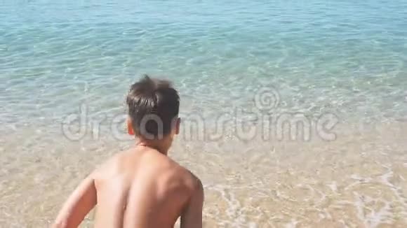 小男孩从海滩跑到海里慢动作视频的预览图