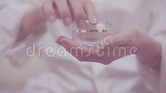 嫩嫩的女人手打开和关闭护肤霜玻璃罐的特写镜头漂亮的手优雅的法式视频的预览图