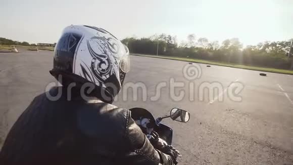 一个戴着头盔的年轻骑自行车的人骑着他的摩托车特写视频的预览图