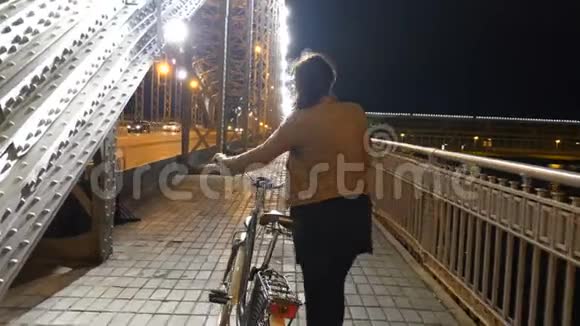 晚上城里的女游客骑着自行车圣彼得堡的桥梁视频的预览图