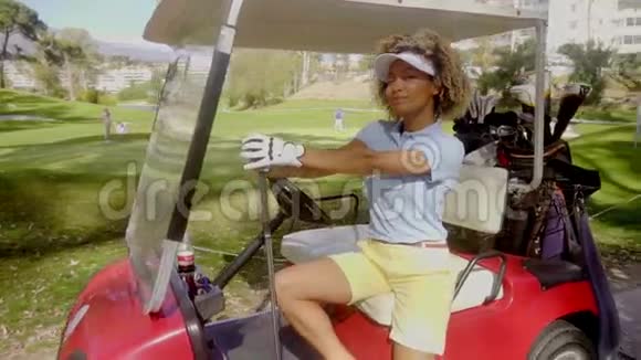穿红色高尔夫球车的漂亮年轻女子高尔夫球手视频的预览图