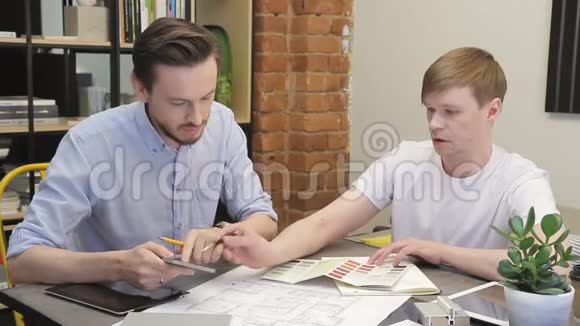 两位设计师在餐桌上工作在客厅里挑选颜色视频的预览图