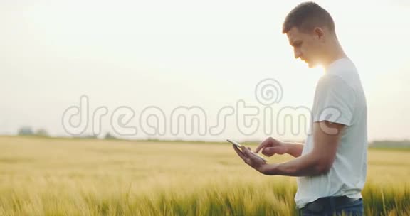 农民看着他的黑麦地用他的数字平板电脑视频的预览图