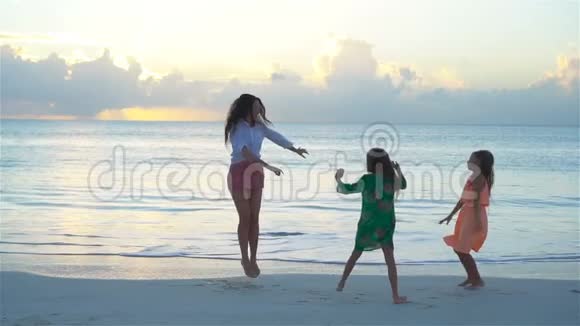 妈妈和孩子们享受海滩暑假热带假期一家人在白色海滩跳舞流动人口视频的预览图