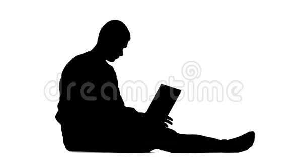 一个人坐在地板上玩电脑剪影白色背景视频的预览图