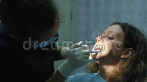 正畸医生在安装支架系统之前将凝胶涂在牙齿上去看牙医视频的预览图