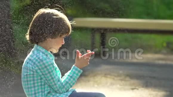 孩子们在绿色公园夏天户外玩手机孩子用无线网络可爱的快乐男孩在网上写短信视频的预览图