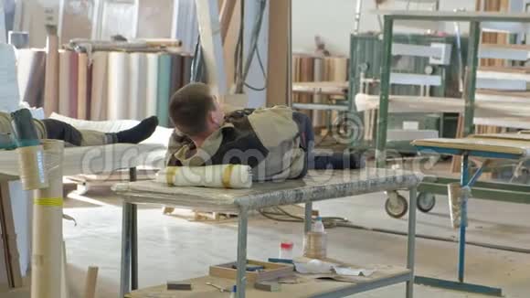 工人休息和使用电话在工作场所休息木质室内门的生产视频的预览图