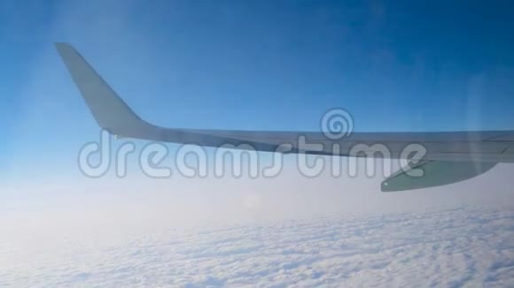 飞机的机翼飞过云层透过肮脏的窗户看到倒影视频的预览图