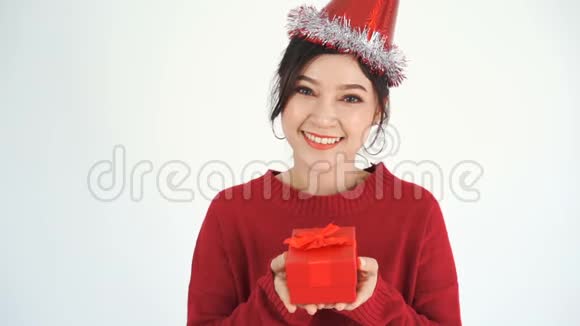 带着帽子拿着一个红色圣诞礼品盒的快乐女人的慢动作视频的预览图
