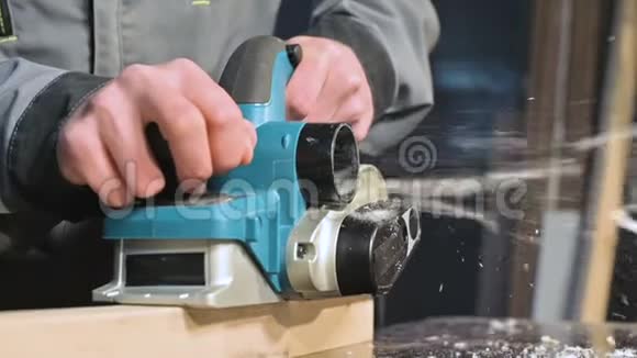 大特写木工用电平面切割木板尘埃粒子和锯片的缓慢运动视频的预览图