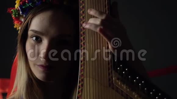 一个黑背景的女孩演奏传统的绷带乐器视频的预览图